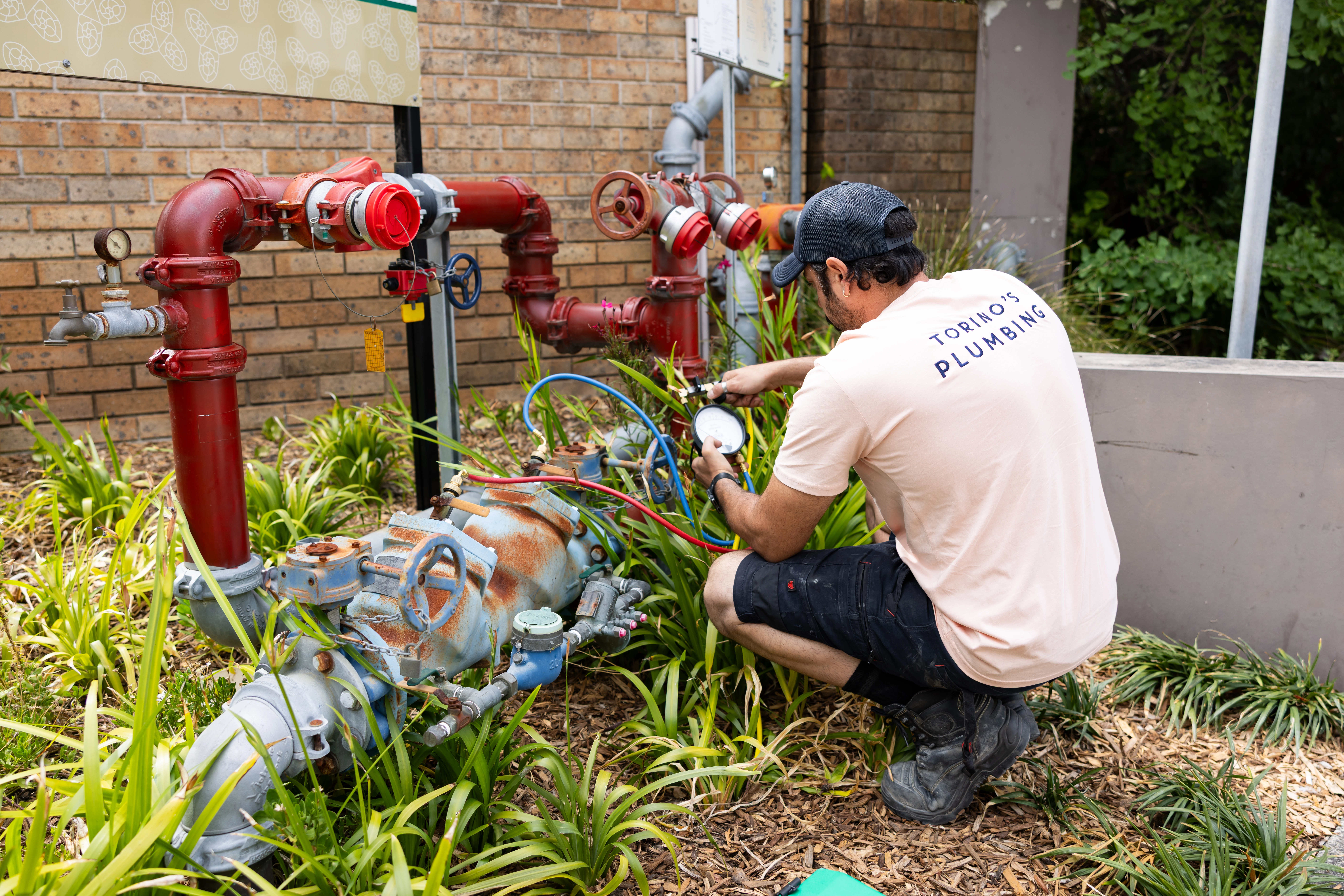 Technician tightening pipe fittings in Manly