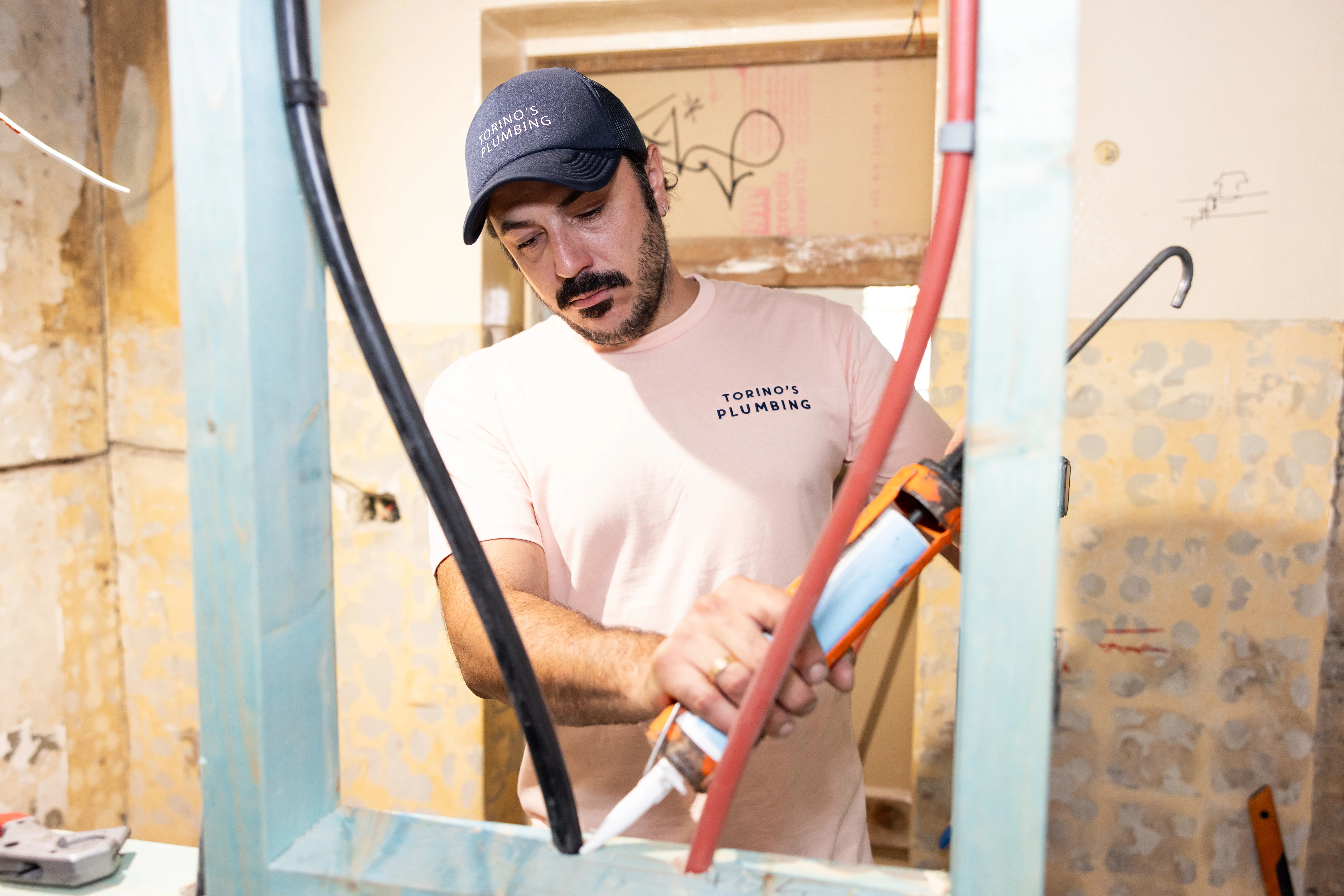 Plumber fixing gaps with silicone sealant