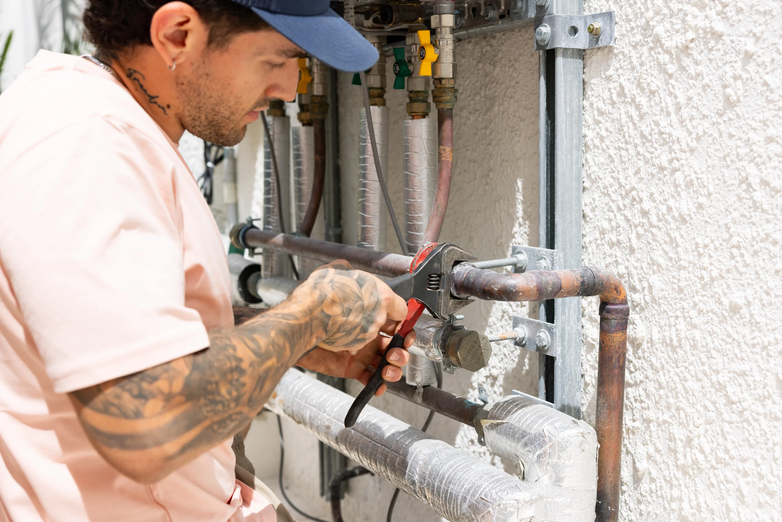 Plumber using tools to tighten pipe fittings