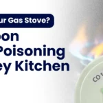 A gas stove with a yellow flame next to a carbon monoxide detector, highlighting safety warnings about carbon monoxide in kitchens.